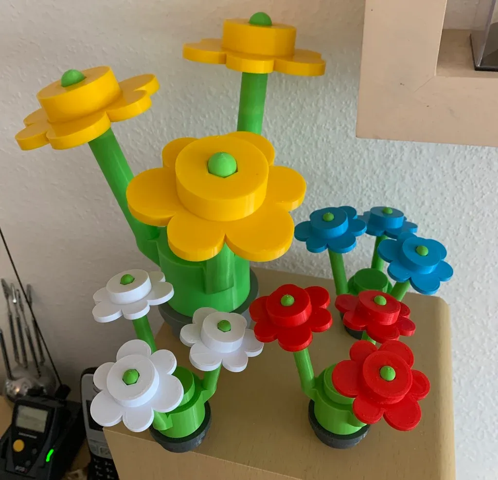 A cluster of 3D-printed Lego-style flowers in yellow, blue, red and white with green stems