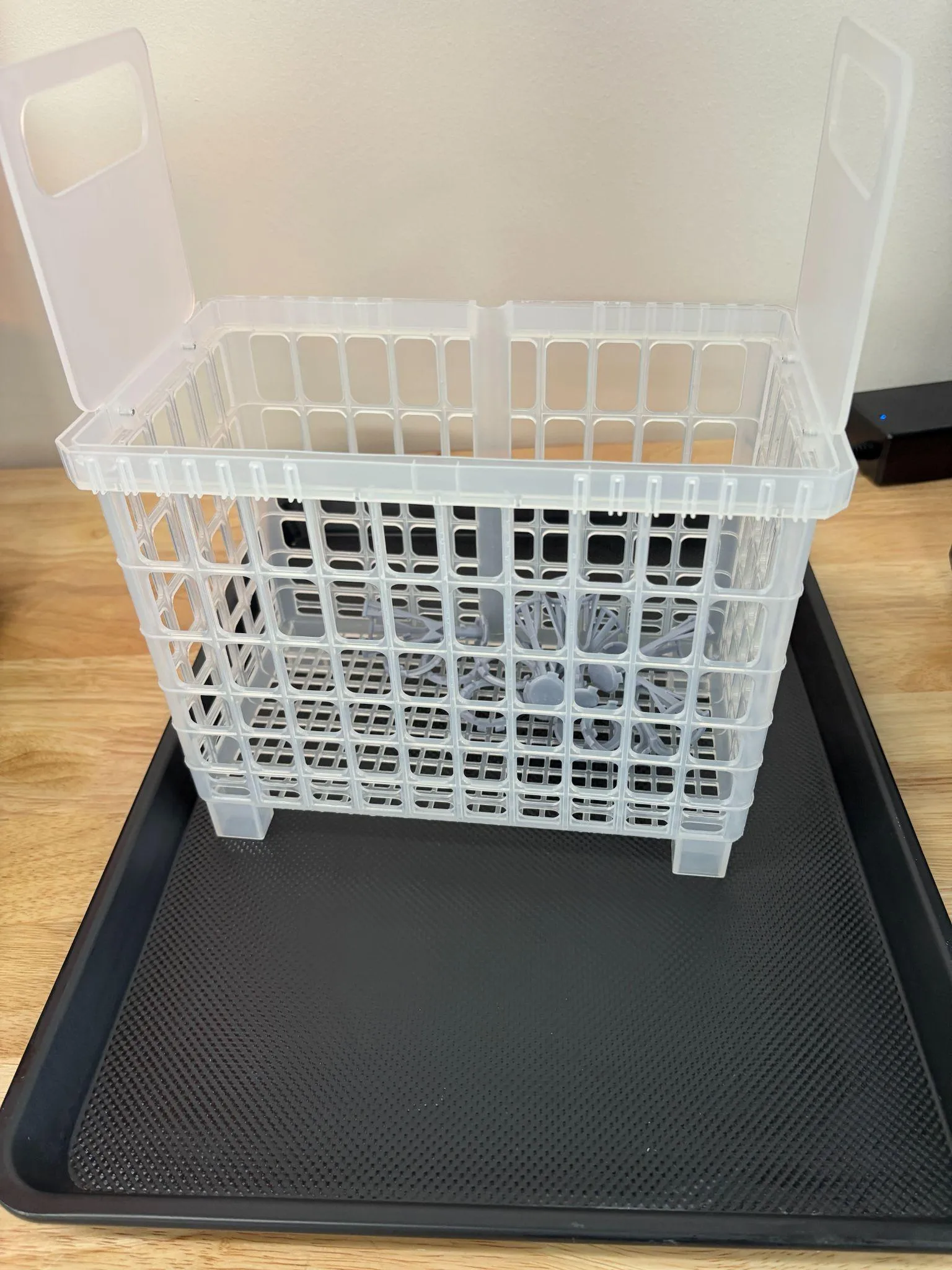 The cleaning basket standing on a black baking sheet, draining