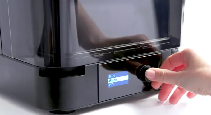 A hand turning the Form Cure's knob, with the display showing Start, 45 min and 48 degrees C